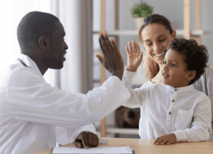 trusting kid with doctor celebrate good medical health care treatment result